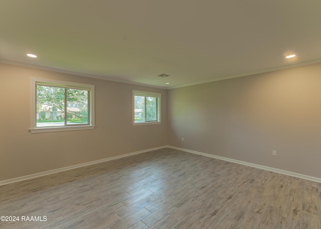 spare room with crown molding and light hardwood / wood-style floors