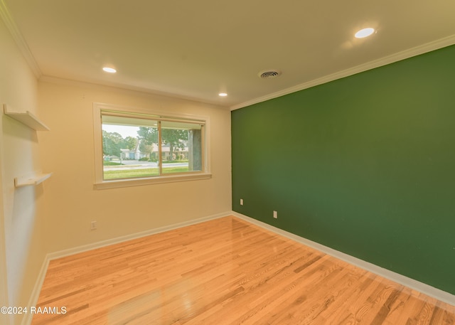 unfurnished room with crown molding and light wood-type flooring