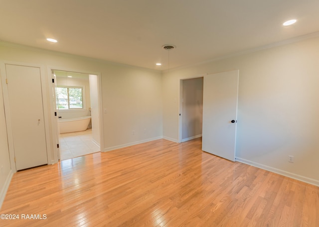 spare room featuring ornamental molding and light wood-type flooring