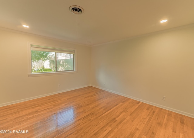 empty room featuring ornamental molding and light hardwood / wood-style floors