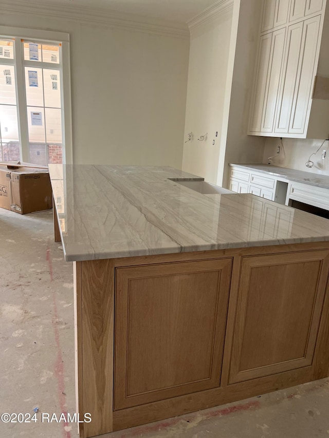 kitchen with light stone counters and crown molding