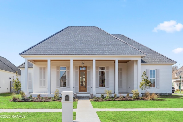 view of front of home with covered porch, a front lawn, and a shingled roof