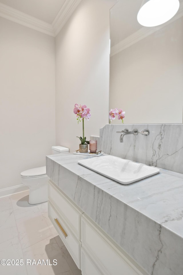 bathroom featuring ornamental molding, marble finish floor, a sink, and toilet