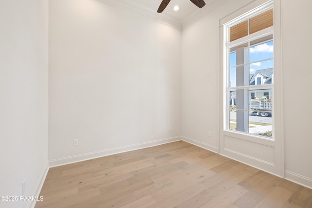 unfurnished room featuring light wood-style floors, a wealth of natural light, ornamental molding, and baseboards