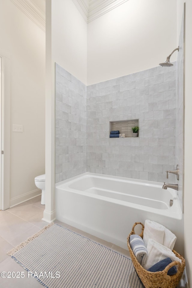 bathroom featuring baseboards, crown molding, toilet, and tile patterned floors