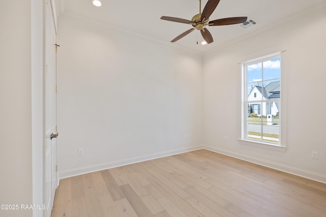 unfurnished room featuring light wood-style flooring, visible vents, ornamental molding, and baseboards