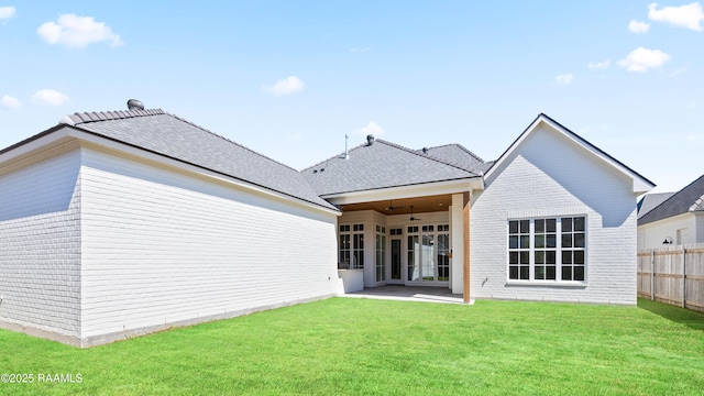 back of property featuring brick siding, a patio, a lawn, ceiling fan, and fence