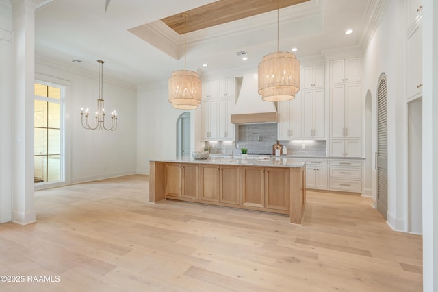 100 Winthorpe Row, Lafayette, LA 70503 - kitchen with light wood-style flooring, a raised ceiling, ornamental molding, and premium range hood