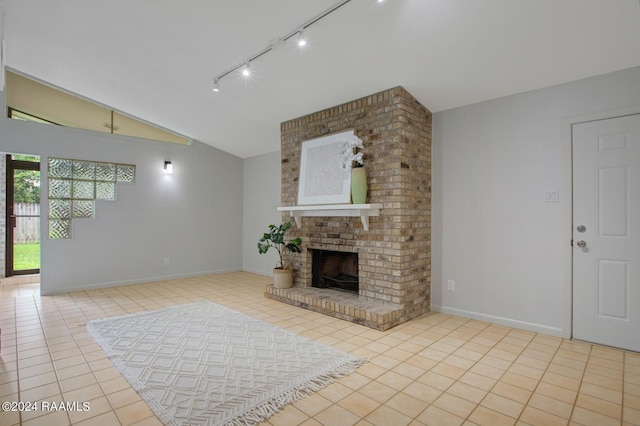 unfurnished living room with a fireplace, light tile patterned floors, track lighting, and vaulted ceiling