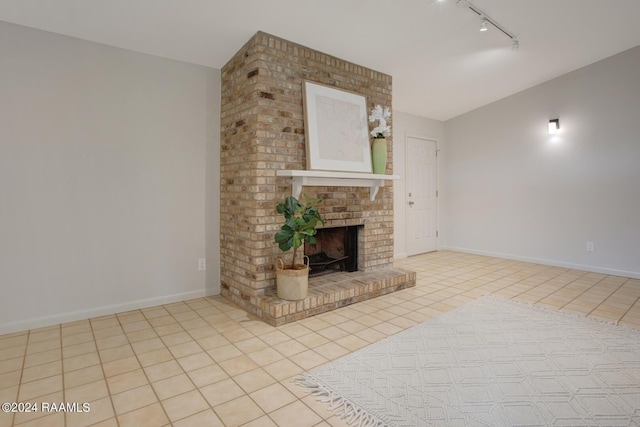 unfurnished living room featuring a fireplace, light tile patterned floors, and track lighting