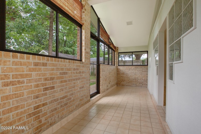 unfurnished sunroom featuring vaulted ceiling