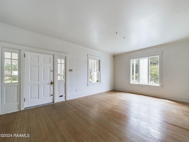 foyer entrance with crown molding and hardwood / wood-style floors