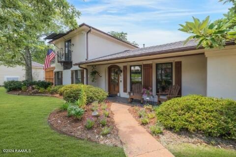 view of front of house featuring covered porch and a front lawn