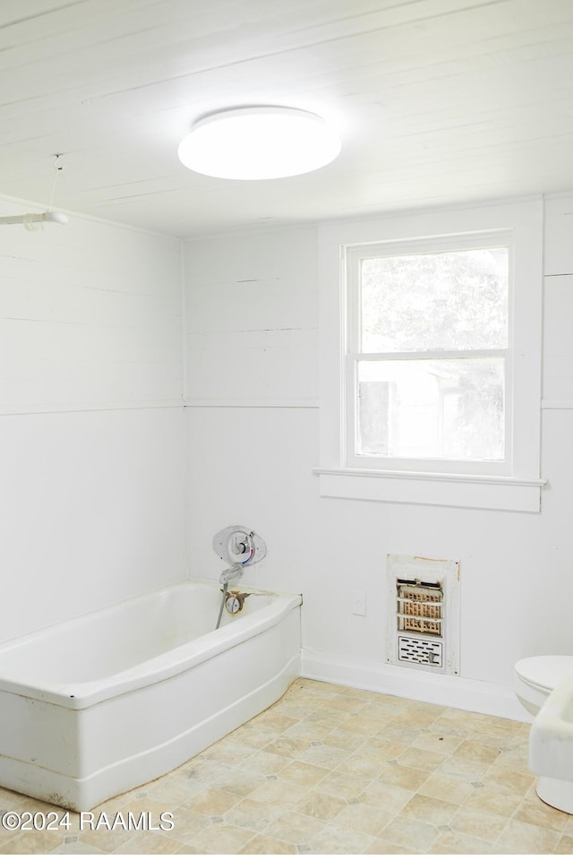 bathroom featuring toilet and a washtub