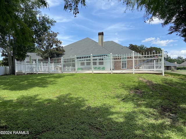 rear view of house featuring a lawn