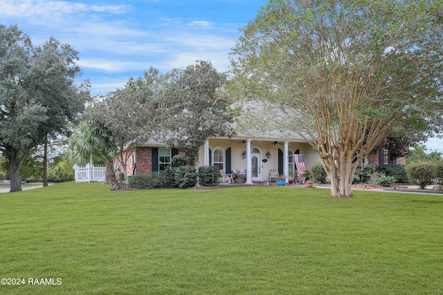 view of front facade with ceiling fan, a porch, and a front yard