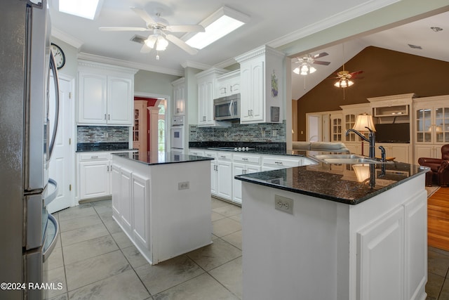 kitchen with white cabinets, sink, a kitchen island, kitchen peninsula, and stainless steel appliances