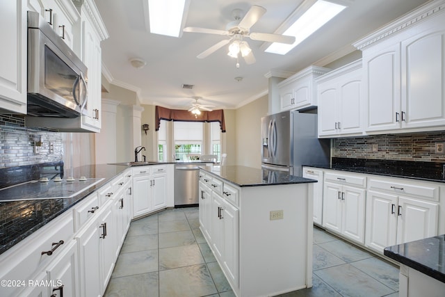 201 Marquette St, New Iberia, LA 70563 - kitchen featuring appliances with stainless steel finishes, ceiling fan, a peninsula, tasteful backsplash, and ornamental molding