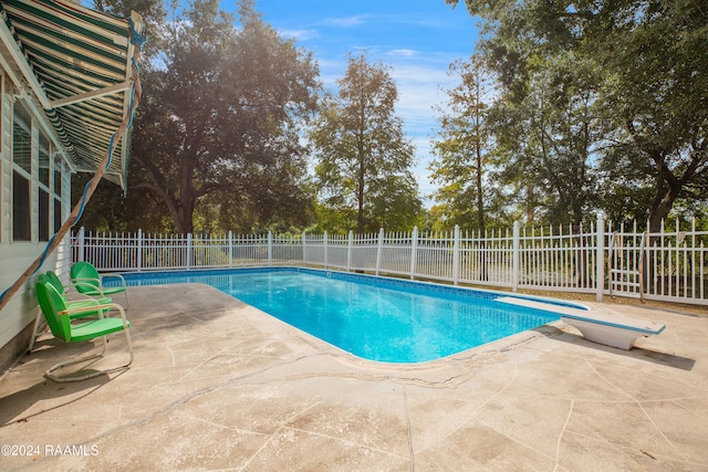 view of pool featuring a diving board and a patio area