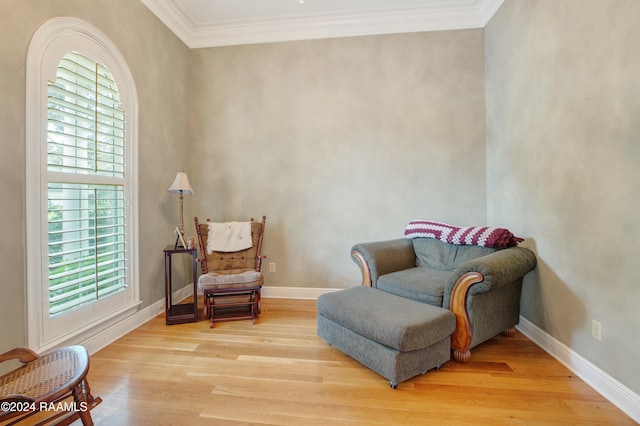 sitting room with light hardwood / wood-style floors, plenty of natural light, and crown molding