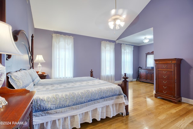 bedroom with ceiling fan, light hardwood / wood-style floors, and vaulted ceiling