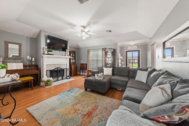 living room featuring ceiling fan, lofted ceiling, hardwood / wood-style floors, and a fireplace