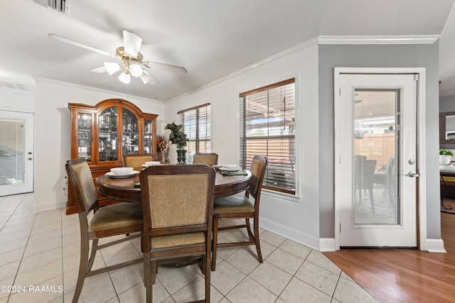 tiled dining area with crown molding and ceiling fan