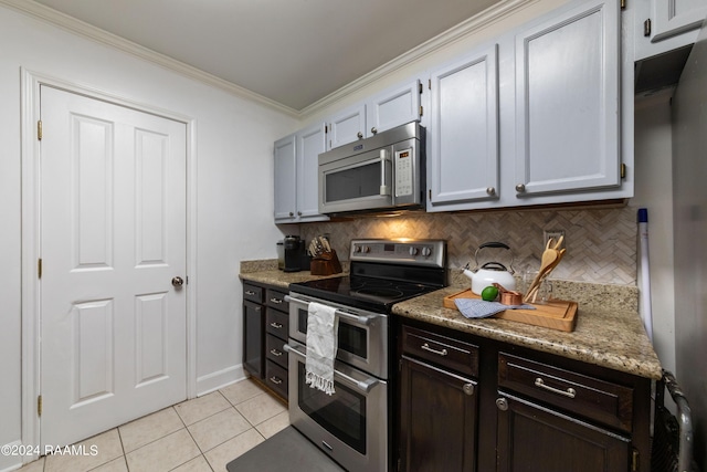 kitchen with light tile patterned flooring, appliances with stainless steel finishes, tasteful backsplash, white cabinets, and ornamental molding