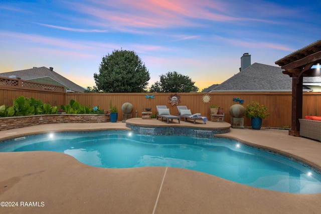 pool at dusk featuring pool water feature and a patio area