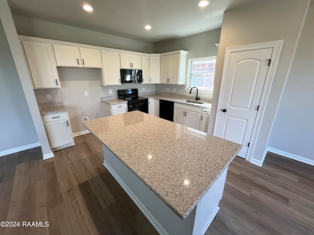 kitchen featuring sink, light stone counters, white cabinetry, and black appliances