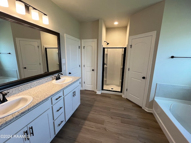 bathroom featuring shower with separate bathtub, vanity, and wood-type flooring