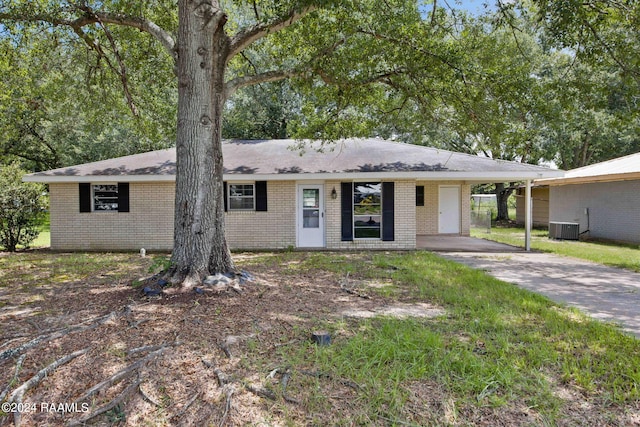 single story home featuring central AC unit and a carport