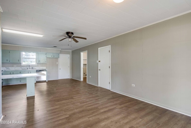 unfurnished living room featuring ceiling fan, dark hardwood / wood-style flooring, ornamental molding, and sink