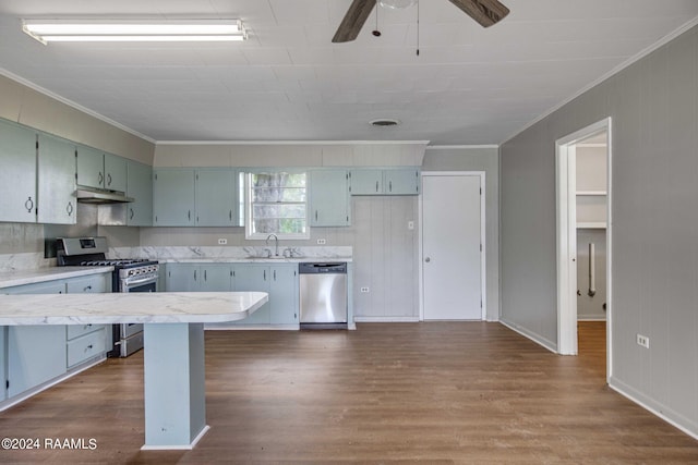 kitchen featuring dark wood-type flooring, stainless steel appliances, and crown molding