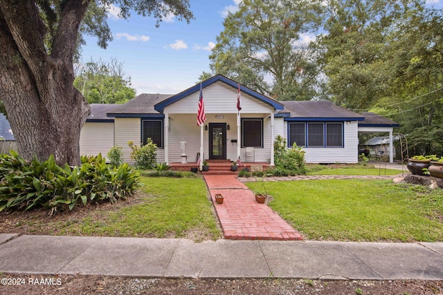 view of front facade with a porch, a carport, and a front lawn