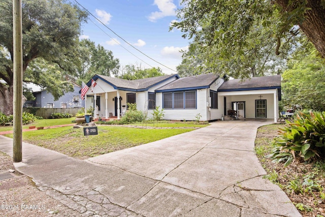 ranch-style house featuring a carport, a porch, and a front lawn