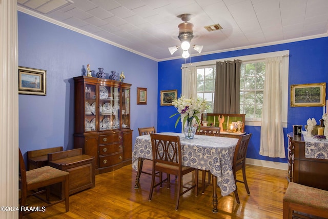 dining space with ceiling fan, ornamental molding, and wood-type flooring