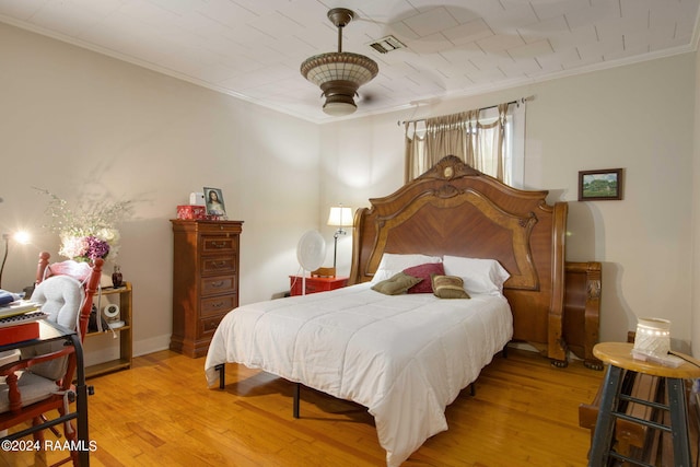 bedroom featuring ornamental molding, light hardwood / wood-style floors, and ceiling fan