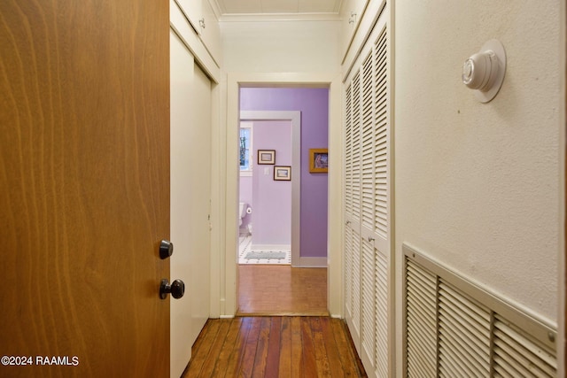 hallway featuring ornamental molding and dark hardwood / wood-style floors