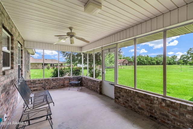 unfurnished sunroom featuring ceiling fan