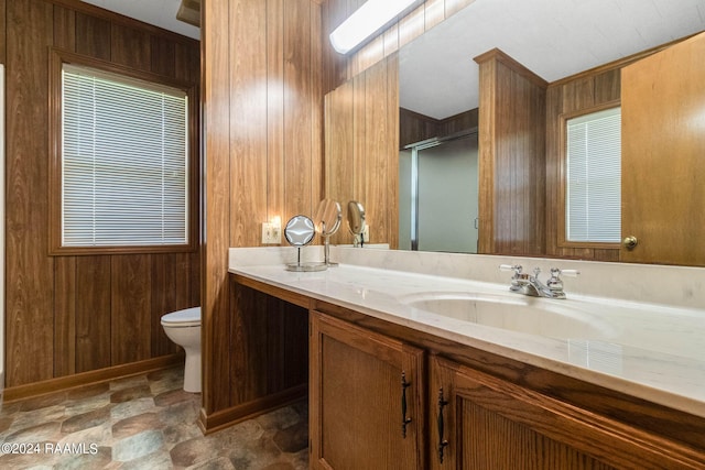 bathroom featuring walk in shower, wooden walls, vanity, and toilet