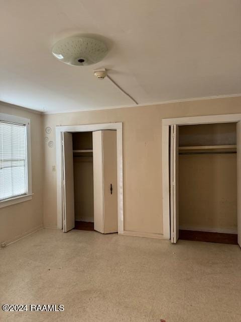 unfurnished bedroom with two closets