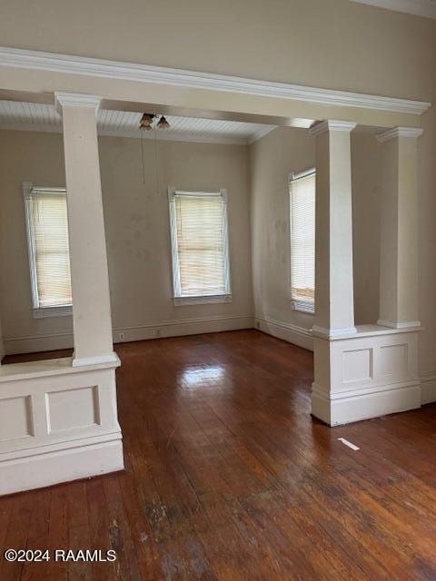 unfurnished room with dark hardwood / wood-style floors and decorative columns