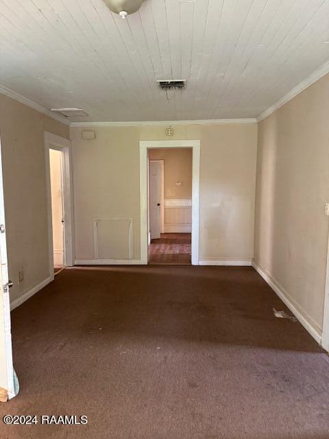 carpeted empty room featuring crown molding