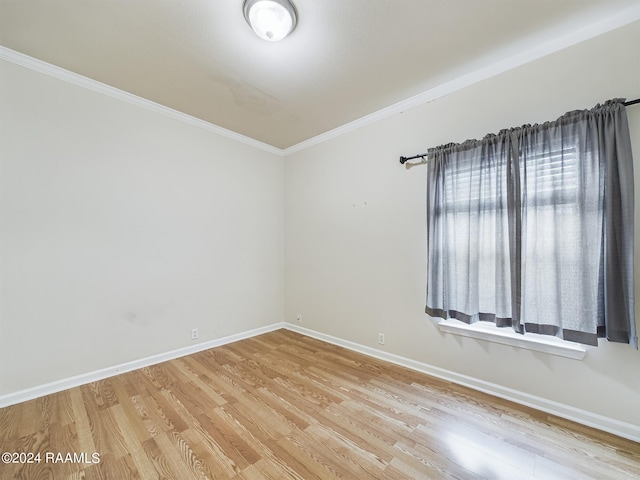 empty room with light wood-style floors, baseboards, and ornamental molding