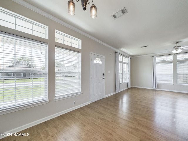 entrance foyer with crown molding, baseboards, visible vents, and light wood finished floors