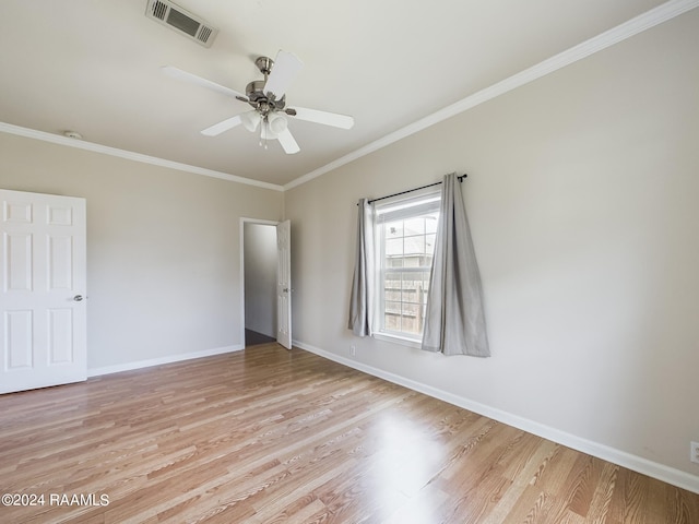 empty room with visible vents, baseboards, light wood-type flooring, ornamental molding, and a ceiling fan