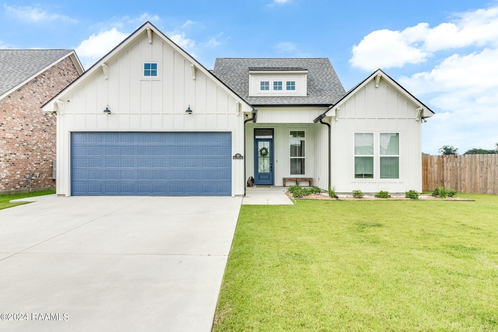 modern inspired farmhouse featuring a front yard and a garage