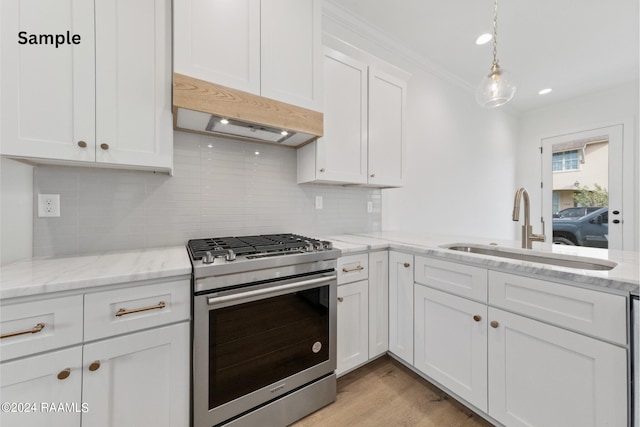 kitchen featuring white cabinets, sink, gas range, crown molding, and light hardwood / wood-style floors