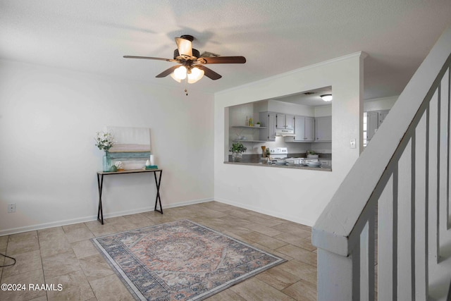 entryway with stairway, a ceiling fan, baseboards, and a textured ceiling